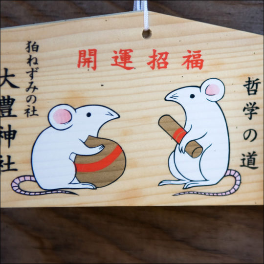 Wooden Ema boards with temple rats holding scrolls (study) and sake barrels (long happy life). Otoyo Jinga Shrine, Kyoto, Japan